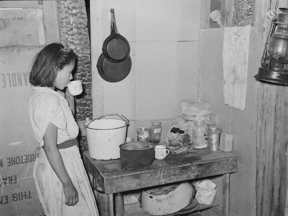 Mexican Girl Drinking A Cup Of Water In The Kitchen Of Her Home In San Antonio, Texas By Russell Lee