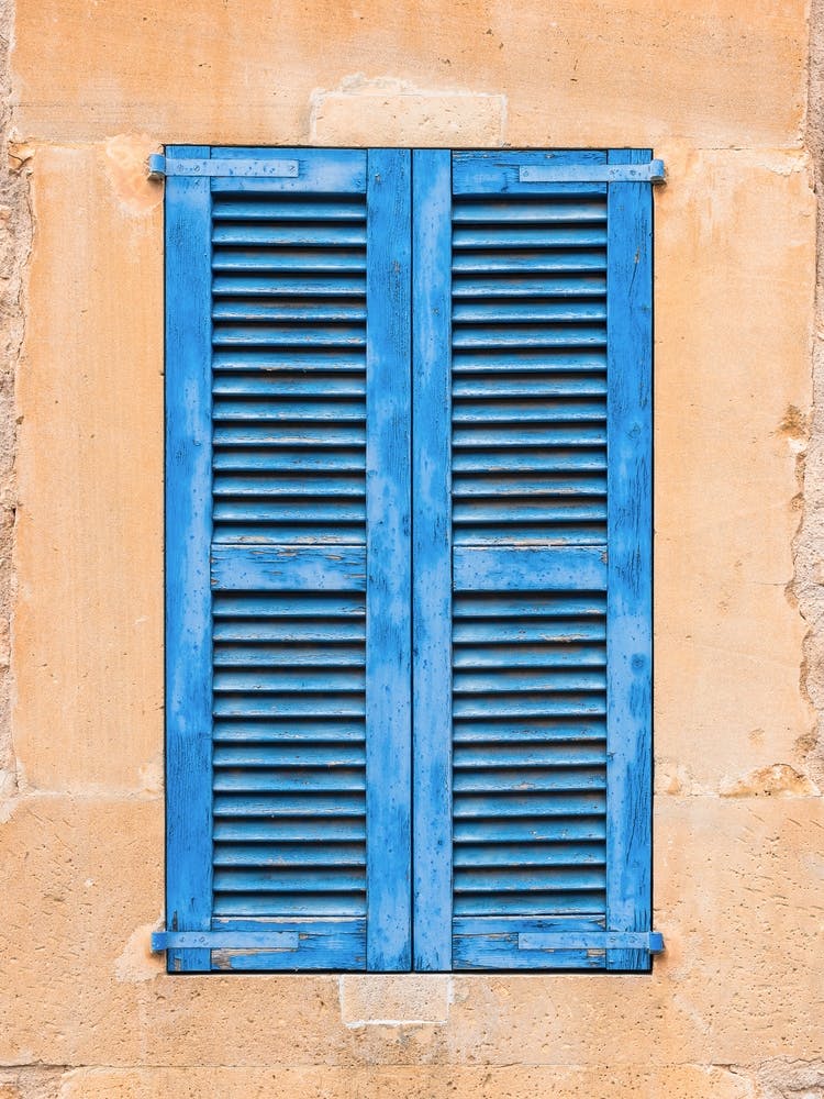 Blue Shutters On A old Wall