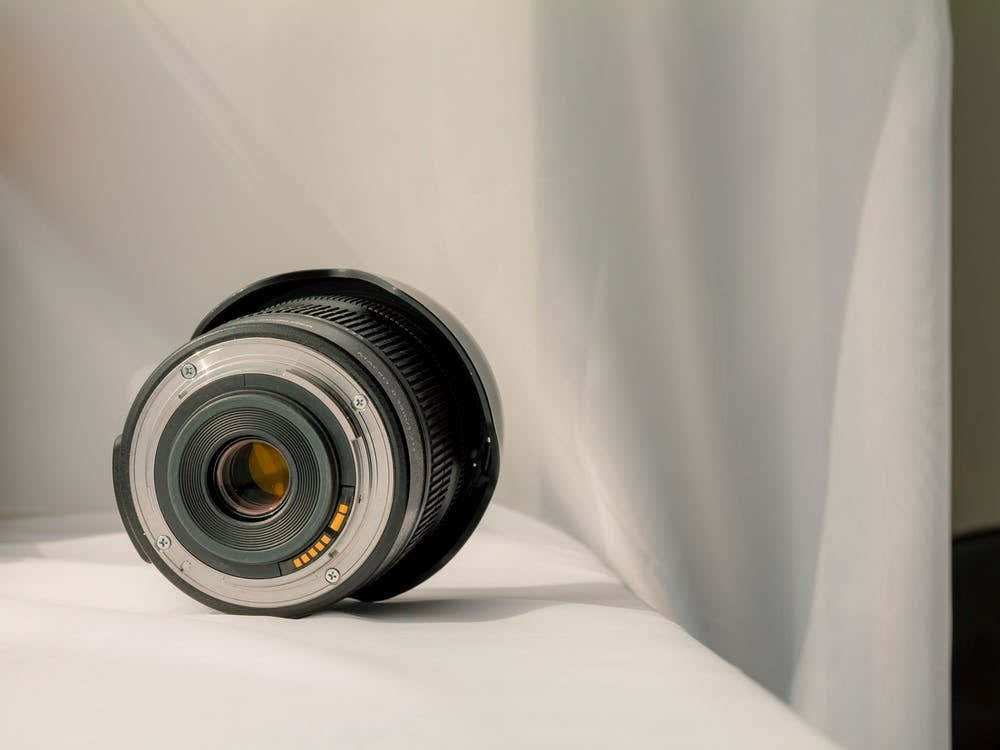 Black Camera Zoom Lens On White Cloth