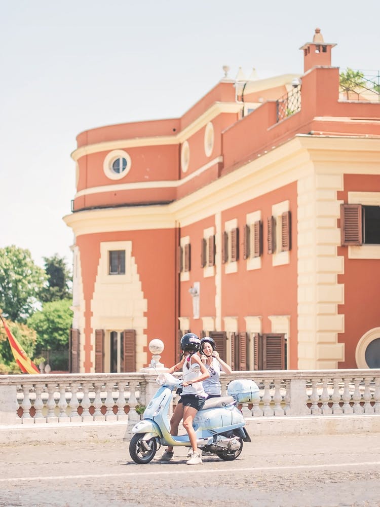 Rome, Italy I Two girls on pastel retro vintage italian scooter in Trastevere, authentic summertime street photography capturing everyday life and la dolce vita vibes aesthetic in city architecture