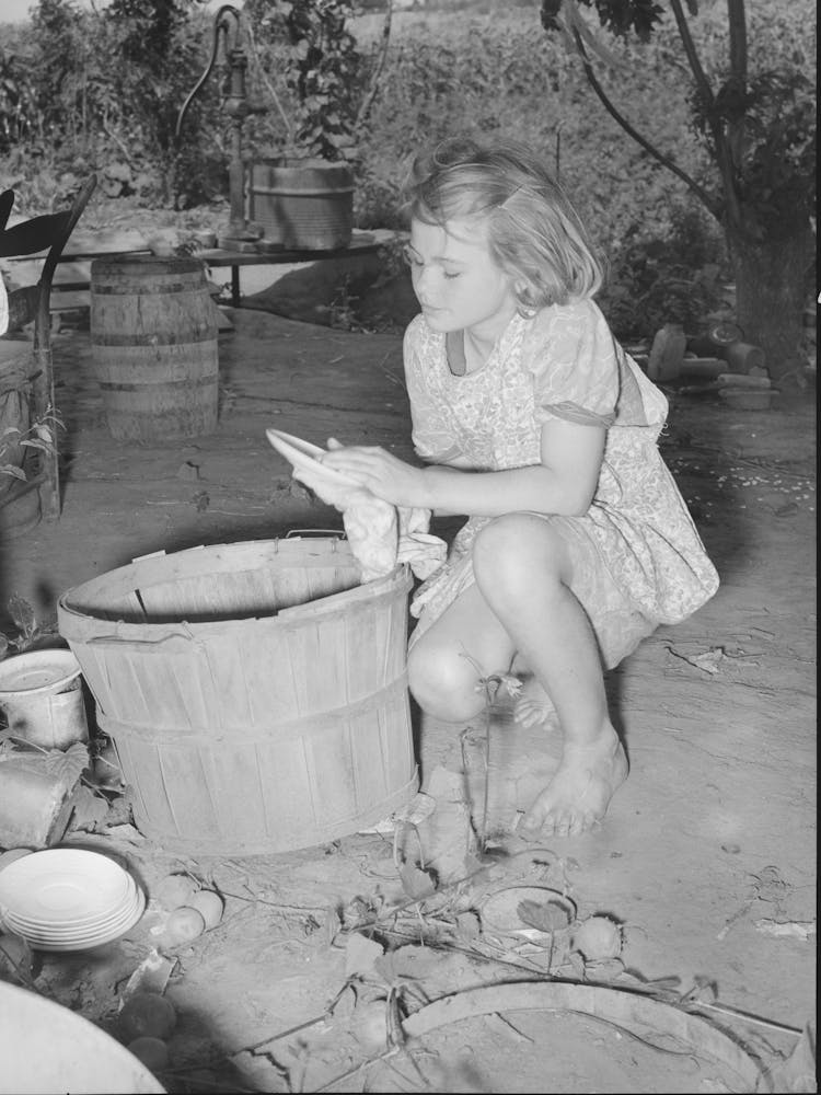 Daughter Of Migrant Family Wiping And Packing Dishes Preparatory To Leaving For California From Muskogee, Oklahoma