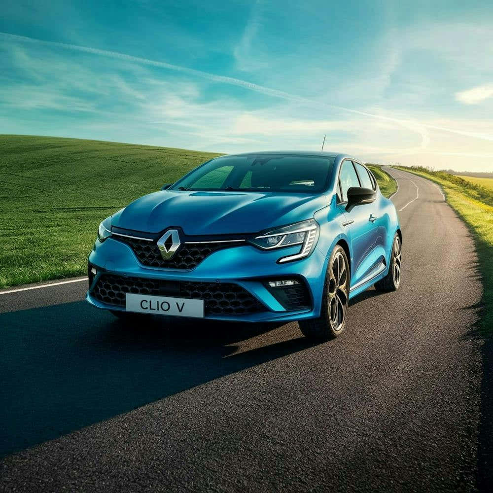 Blue Renault Clio Driving On The Road