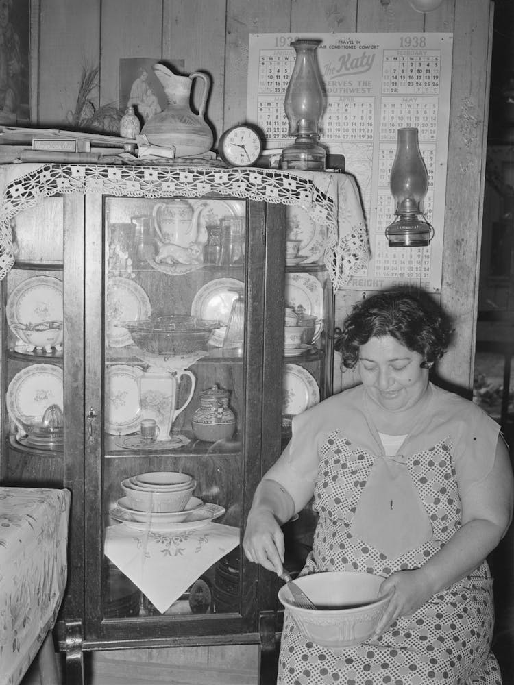 Mexican Woman Beating Cake In Front Of China Cupboard, San Antonio, Texas By Russell Lee