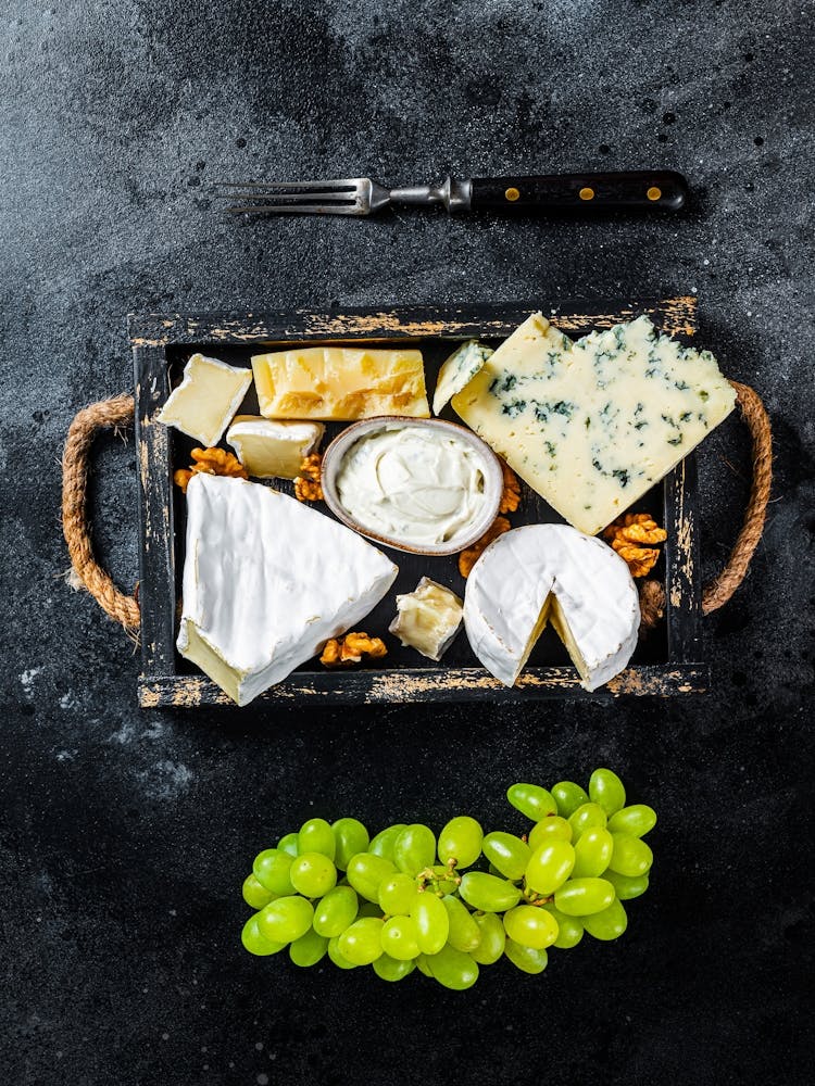 Cheese platter with brie, camembert, roquefort, parmesan, blue cream cheese, grape and nuts — Food kitchen poster/blackboard, photo art
