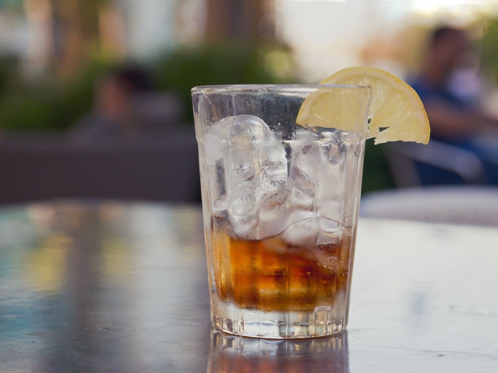 Glass With Cola And Ice And Lemon On A Table Outside 1