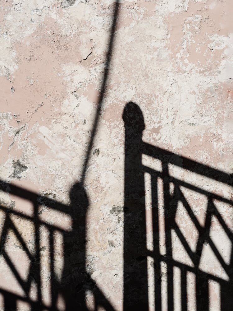 Shadow Of A Fence On A Wall
