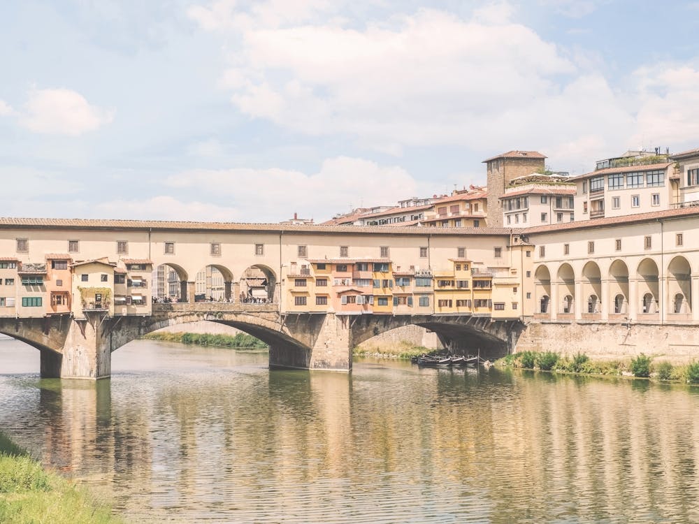 Florence, Italy I Pastel Ponte Vecchio on the Arno to experience dolce vita in Tuscany in sunny to retro vintage atmosphere photography with an Italian summer yellow sunny aesthetic like an old Mediterranean village