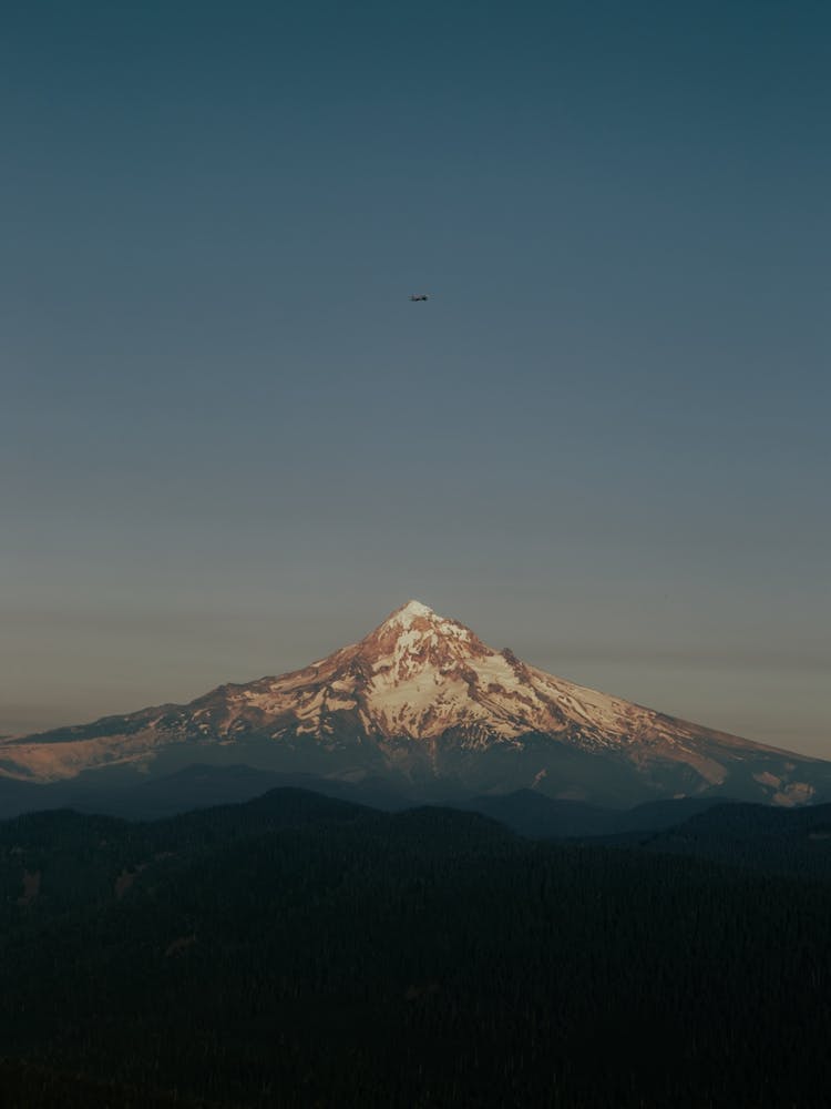 Little Airplane Flying over Mountain Peak