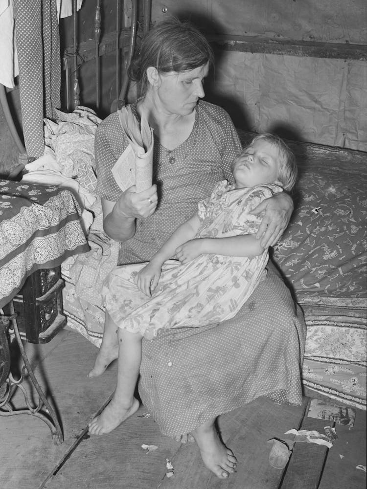 Wife And Daughter Of Agricultural Day Laborer Near Tullahassee, Oklahoma, She Is Fanning Flies Away From Sick Child