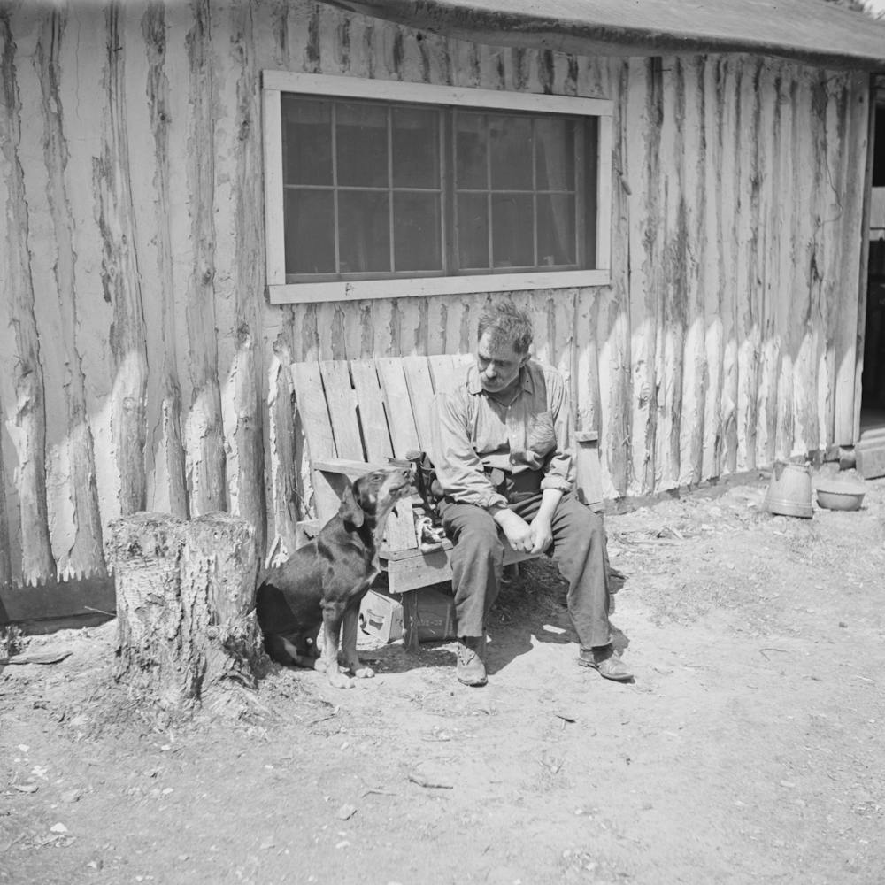 Black Aleck Dickinson et son chien Snoop, Dickinson est un ermite dans le comté d'Iron, Michigan par Russell Lee