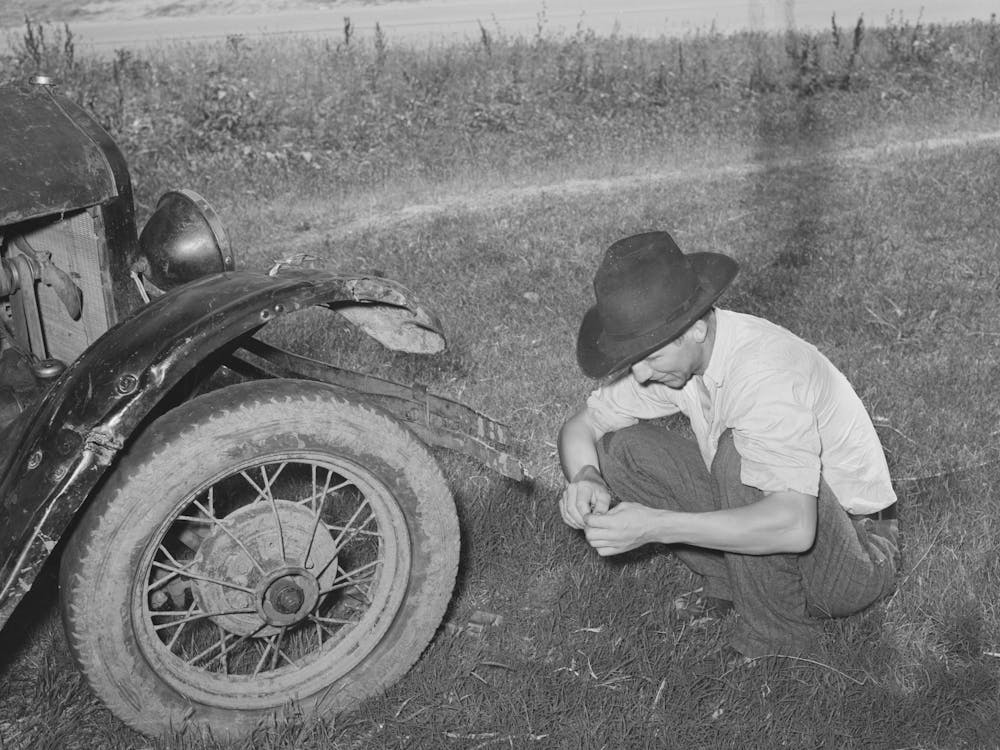 Untitled Photo, Possibly Related To White Migrant Squatting Down In Front Of His Automobile While Camped Near