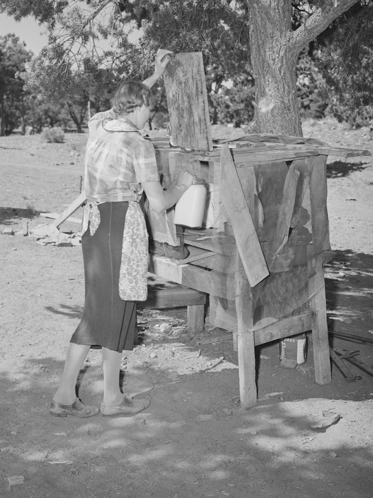 Mrs, Faro Caudill Placing Milk Into Homemade Cooling Box, Damp Cloths Are Wrapped Around Buckets And Jars Of