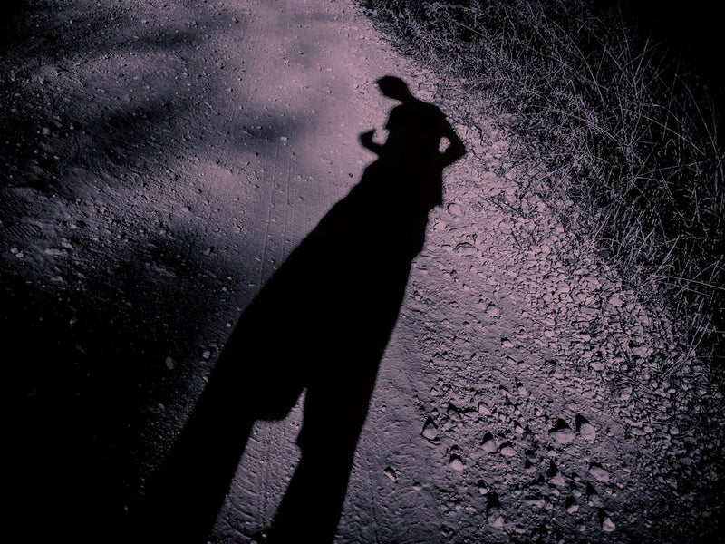 Elongated Shadow Of A Man On Gravel