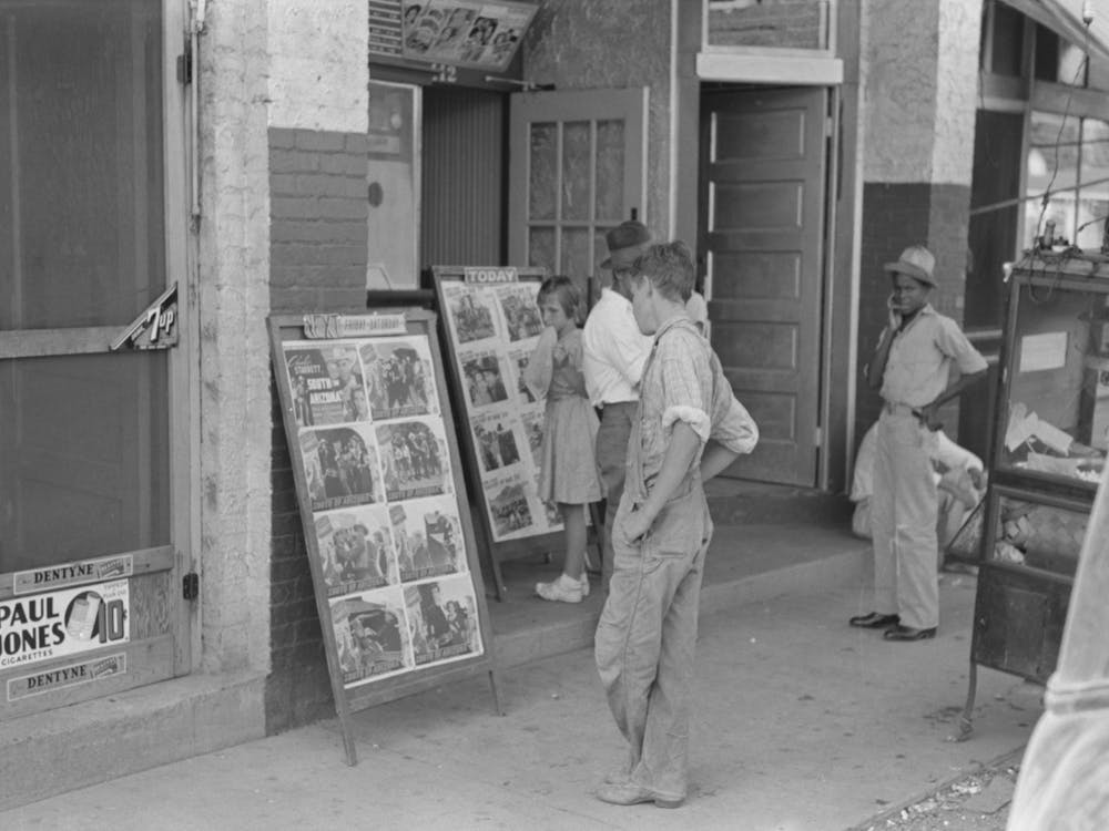 Kinder schauen Plakate vor dem Kino, Samstag, Steele, Missouri von Russell Lee