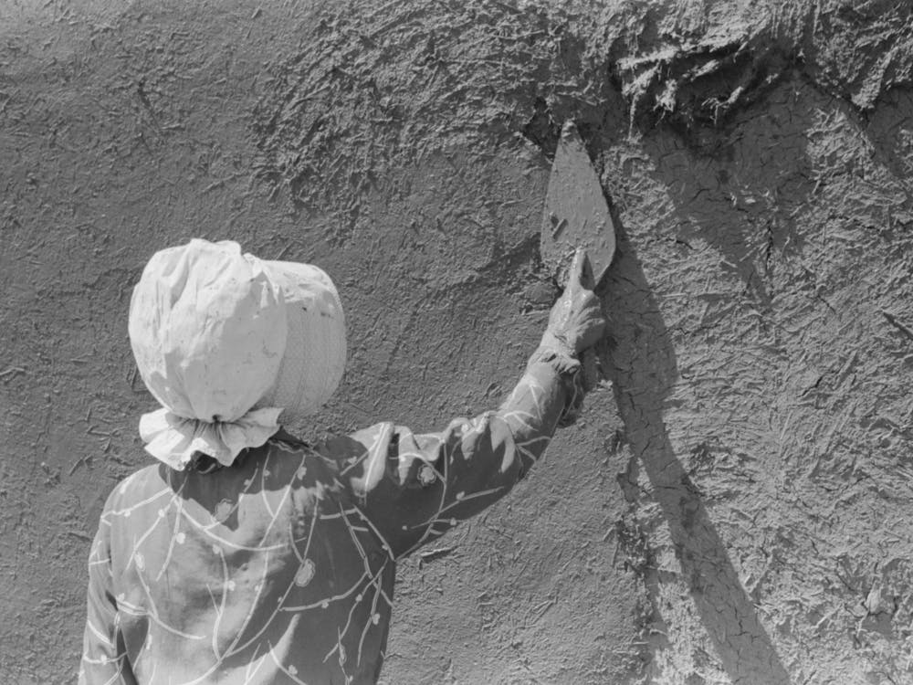 Spanish American Woman Plastering Adobe House, Chamisal, New Mexico By Russell Lee