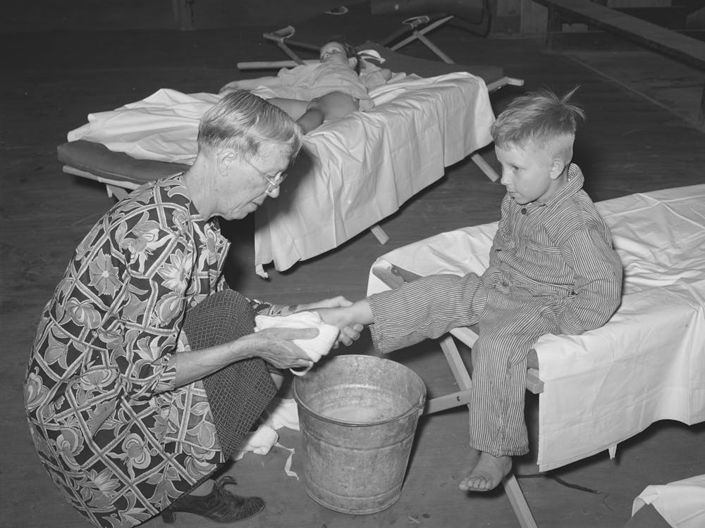 Wpa (Work Projects Administration) Nursery School Attendent Washing Dirty Feet Of The Children Before They Their