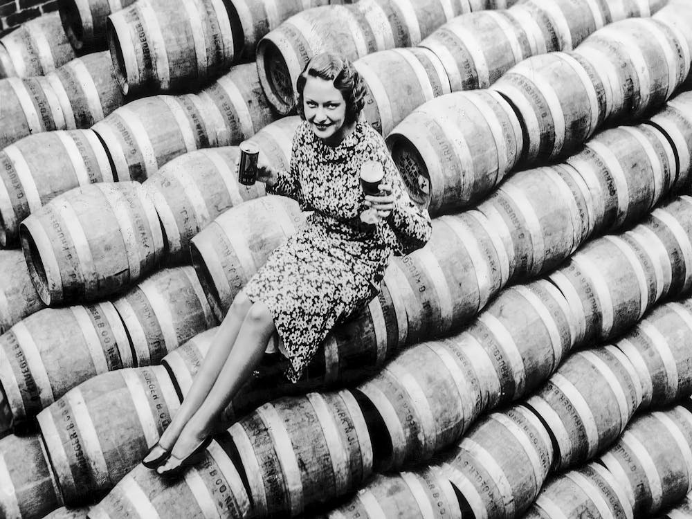 Woman Sitting On Beer Barrels, Black and White Vintage Photo