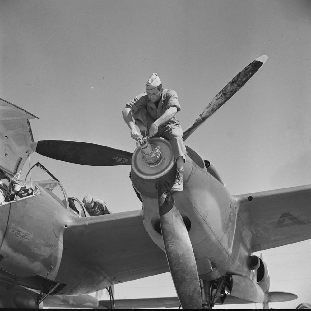 Working On The Nose Of One Engine Of An Interceptor Plane, Lake Muroc, California By Russell Lee