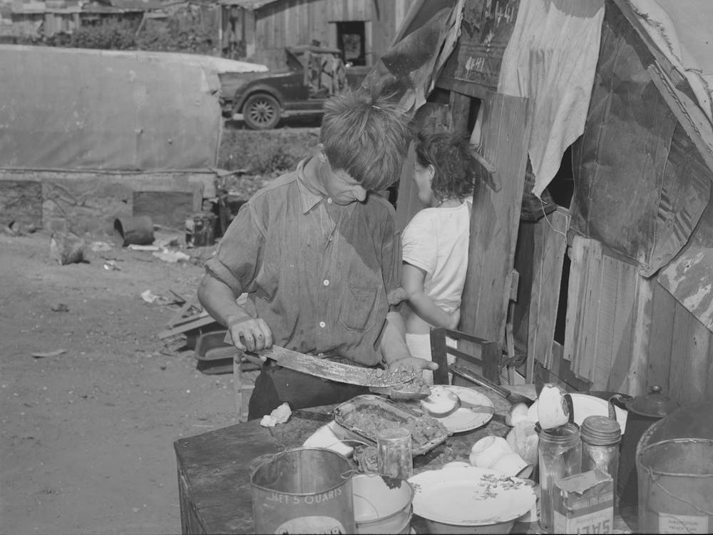 Boy Living In Camp Near Mays Avenue Making Sandwich, This Food Is Distributed By Saint Anthony S Hospital