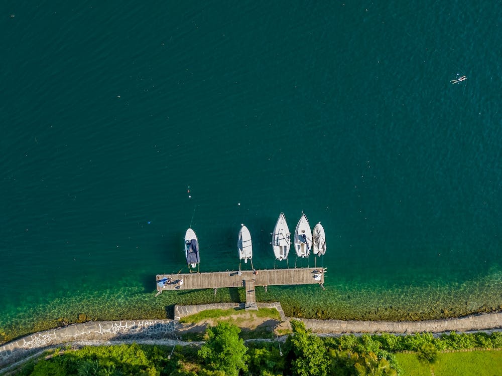 Yachts and sailboats from above, moored on Lake Orta. Piedmont, Italy. Drone photography.