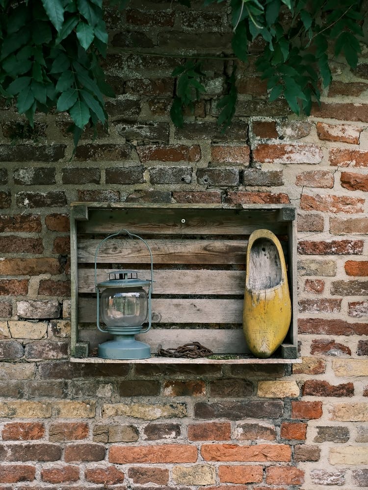 Alte Lampe & Holzschuh an der Ziegelmauer // Die Niederlande // Reisefotografie