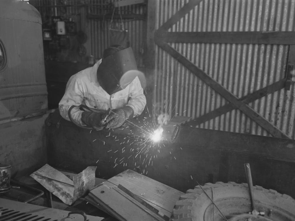 The United Producers And Consumers Cooperative Maintains An Automobile Repair Shop, In This Picture, A Worker