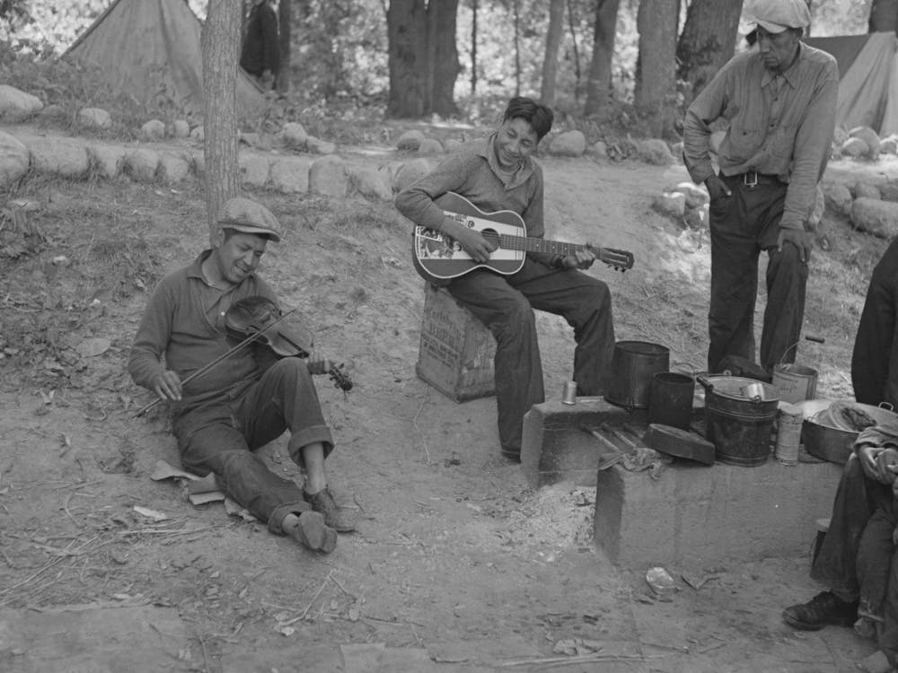 Indianische Jungen spielen Gitarre und Geige im Blueberry Camp nahe Little Fork, Minnesota von Russell Lee