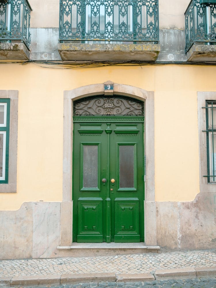 The vintage green door nr. 9 1899 in Alfama, Lisbon, Portugal - summer street and travel photography by Christa Stroo