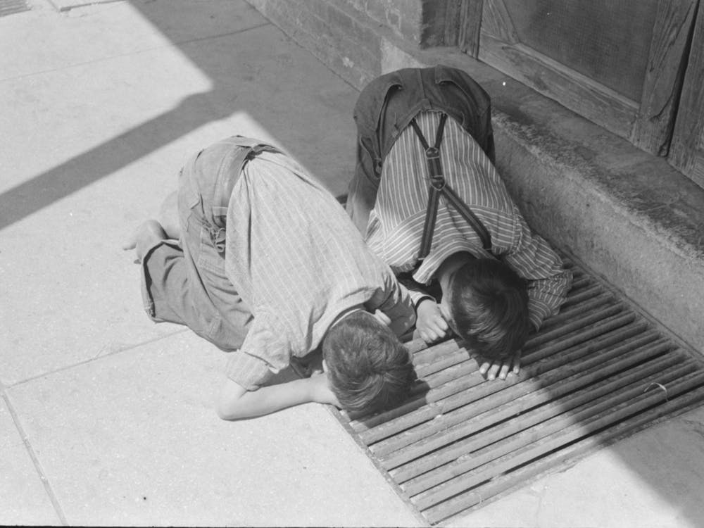 Mexican Boys Peering Through Grating In Sidewalk, San Antonio, Texas By Russell Lee