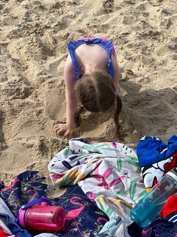 Little Girl Digging In The Sand