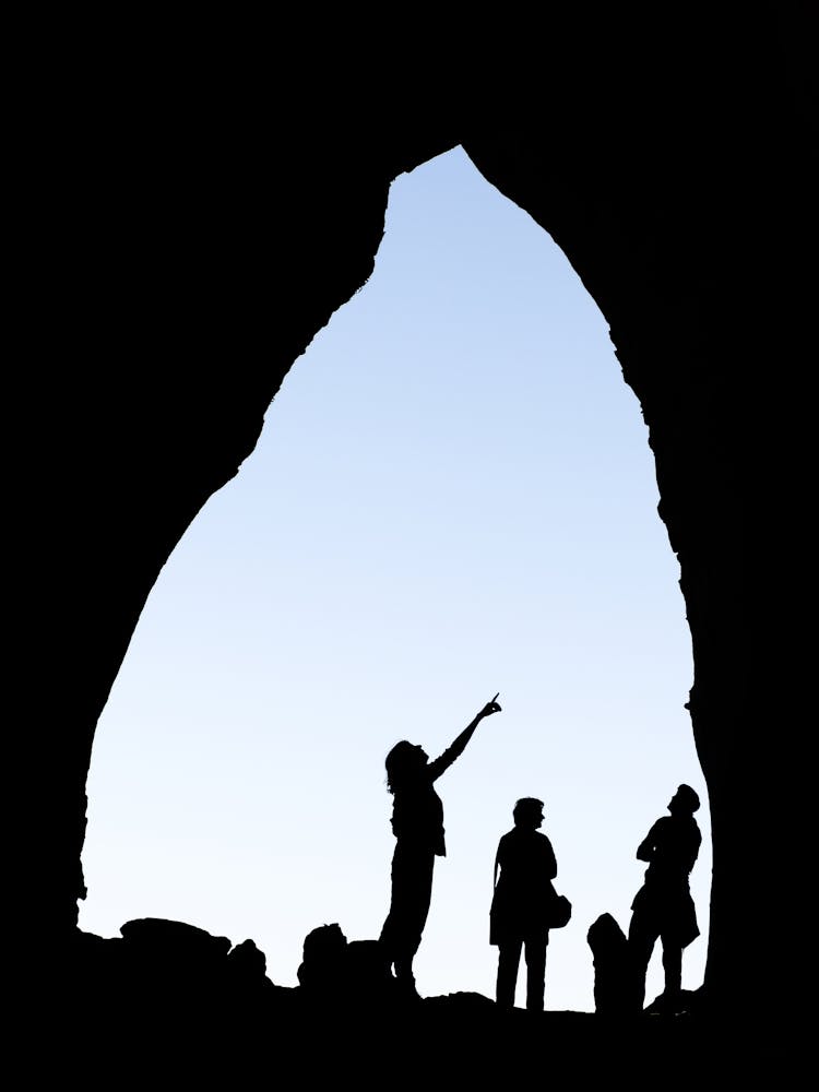 Silhouette Of People In A Cave