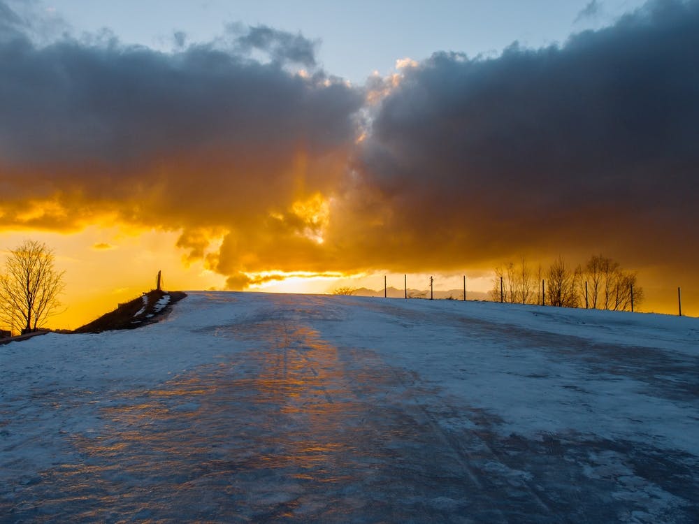 Sunset Over Snow Covered Hill