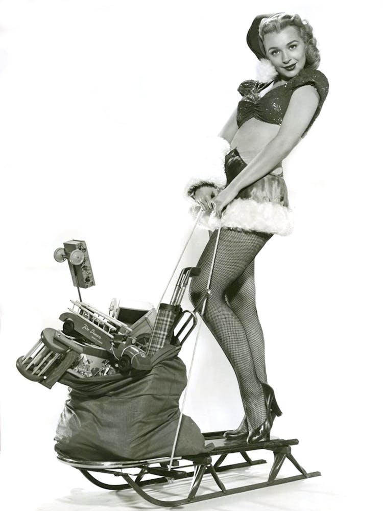 Pinup Girl Posing With Toy Bag On A Sled