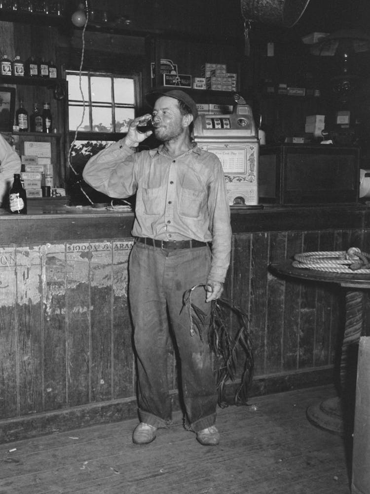 Native Of Olga, Louisiana Drinking At The Bar, Note The Branch Of Tree Used As A Mosquito Switch By Russell Lee