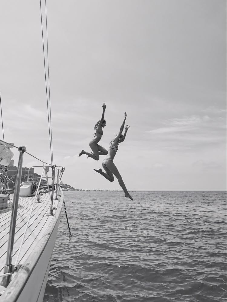 Two Women Jumping Off A Yacht