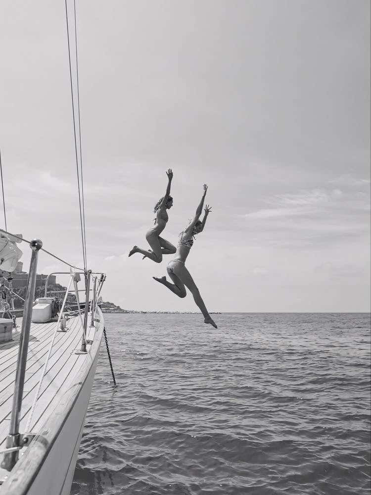 Two Women Jumping Off A Yacht