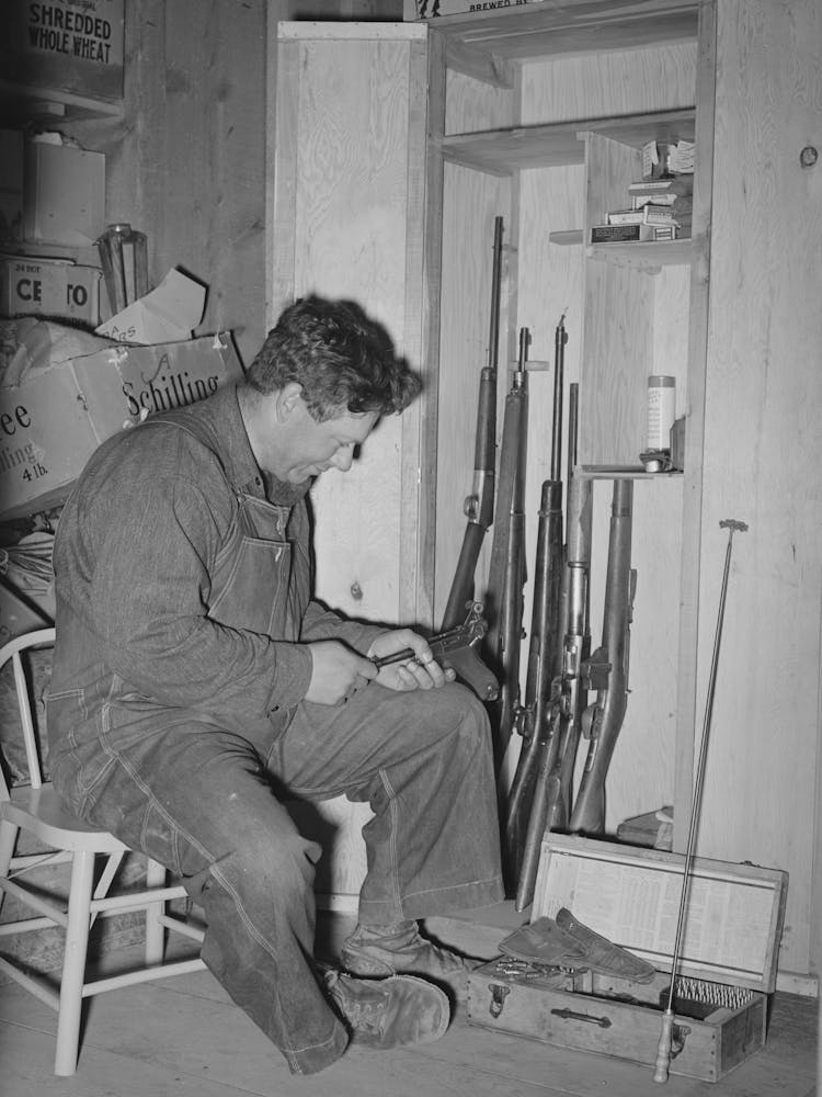 George Hutton Jr, Seine Waffen begutachtend, Pie Town, New Mexico Von Russell Lee