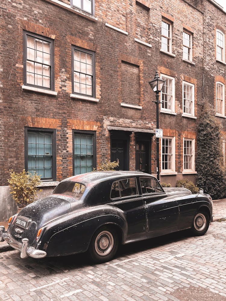 London, England I Antique car on a Shoreditch street with retro vintage aesthetic brick facades with a street photography of British minimalist geometric architecture with a moody ambience