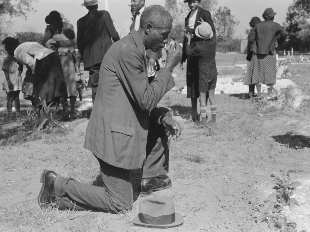 Man Crossing Himself And Praying Over Grave Of Relative In Cemetery, All Saints Day, New Roads, Louisiana By Russell