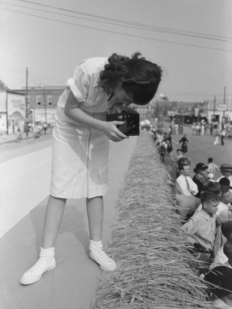Jeune fille prenant une photo de la foule, National Rice Festival, Crowley, Louisiana Par Russell Lee