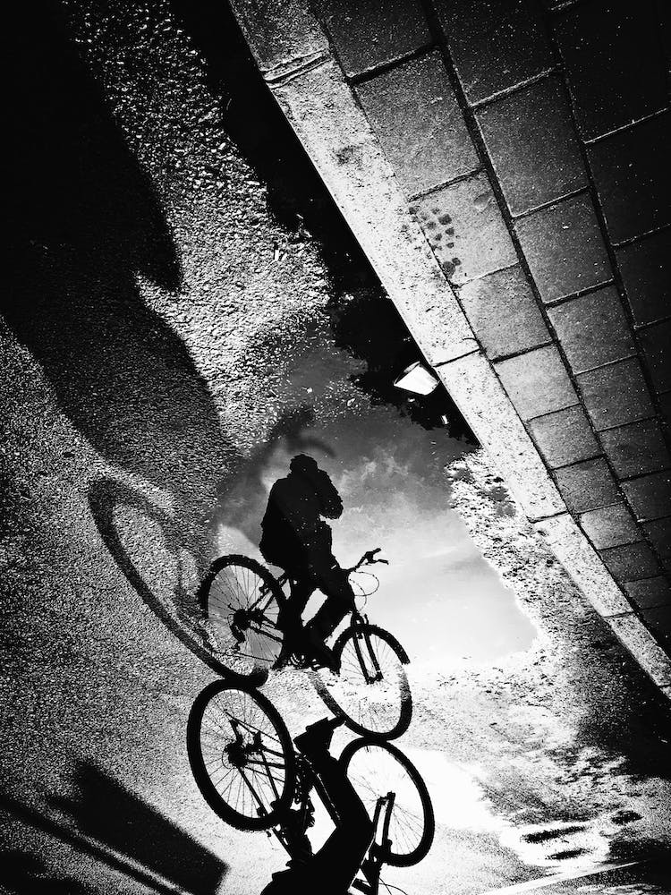 Cyclist On The Puddle