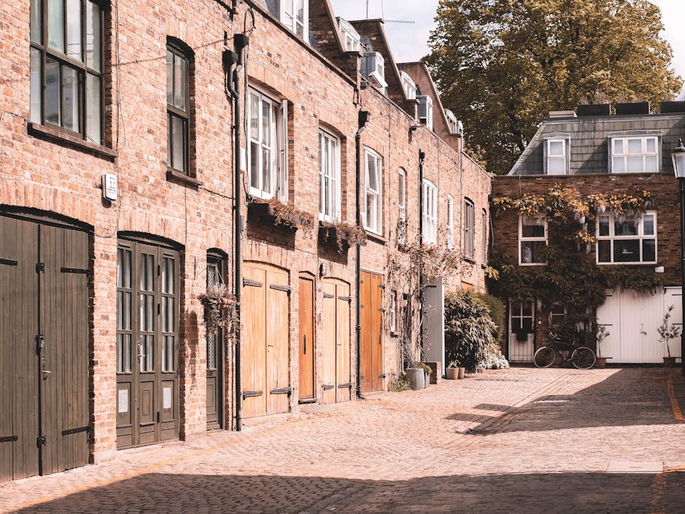 London, England I Notting Hill cobbled street with authentic urban city British brick architecture of a dead end with minimalist geometric composition photography and autumn pastel orange moody aesthetic
