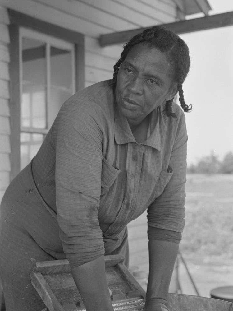 Wife Of Fsa (Farm Security Administration) Client, Former Sharecropper, Washing On Back Porch
