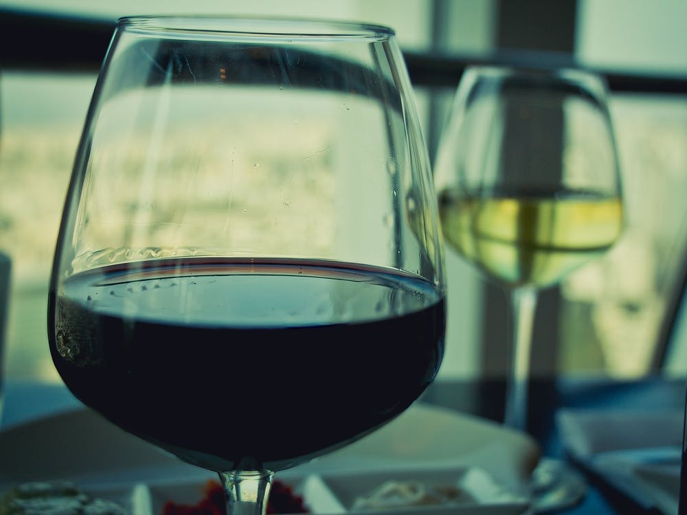 Close Up On Glasses With Red And White Wine On White Table