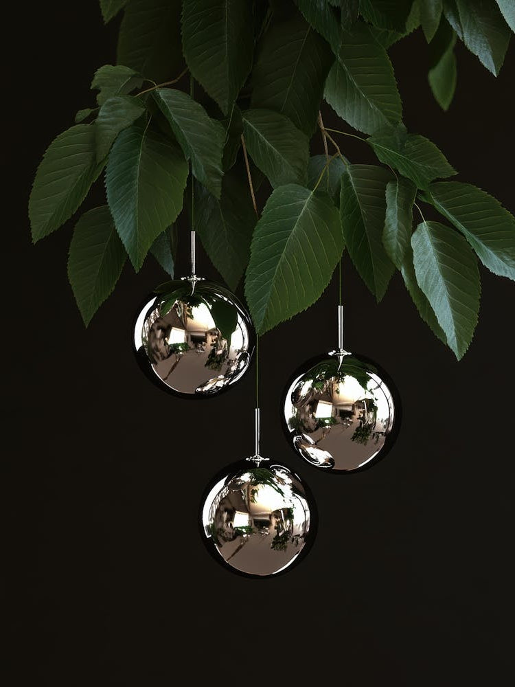 Three Mirrored Balls Hanging From A Tree
