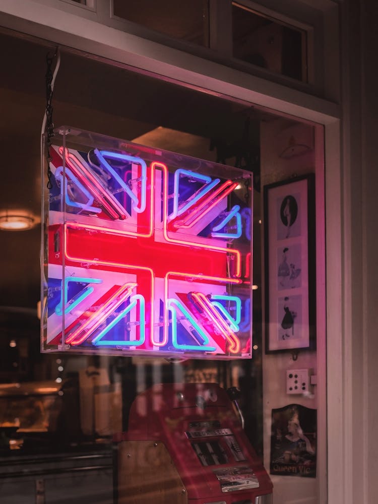 London, England I Neon light of the United Kingdom flag in a moody dark window on a Londoner street to the vibrant cosmopolitan spirit of the English capital with abstract analog film photography