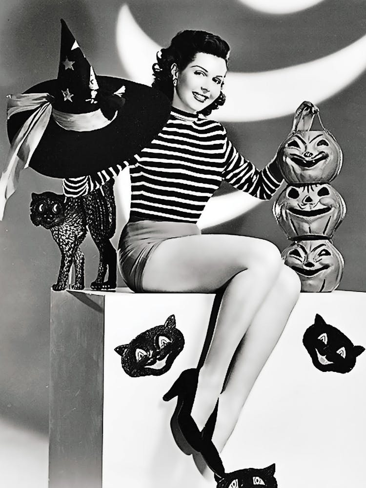 Pinup Sexy Witch Posing With Carved Pumpkins