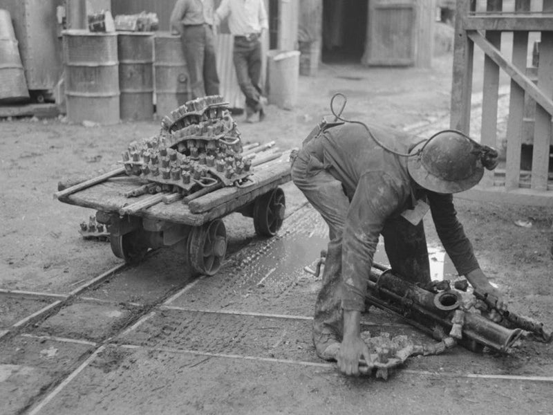 Miner Picking Up Drilling Equipment To Put On Truck, Mogollon, New Mexico By Russell Lee