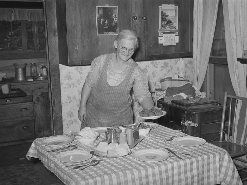 Mrs George Hutton Putting The Food On The Table For Dinner, Pie Town, New Mexico By Russell Lee