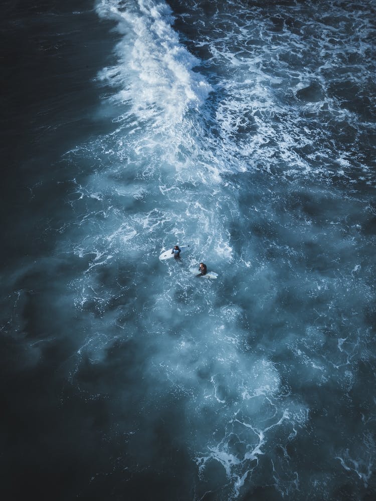 Surfers In Stormy Waters